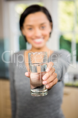 Smiling brunette holding glass of water