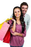 Smiling couple holding colorful shopping bags