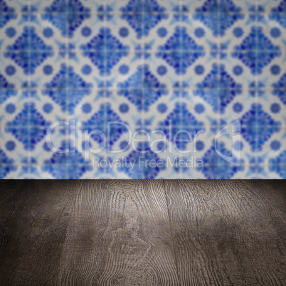 Wood table top and blur vintage ceramic tile pattern wall Wood table top and blur vintage ceramic tile pattern wall
