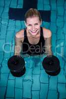 Fit smiling woman holding weights