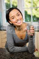 Smiling brunette holding glass of water