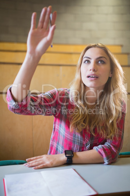 Attractive student raising hand during class