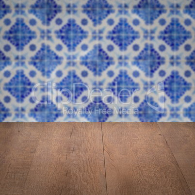 Wood table top and blur vintage ceramic tile pattern wall