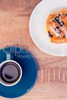 High angle view of sweet food served in plate by coffee cup on t