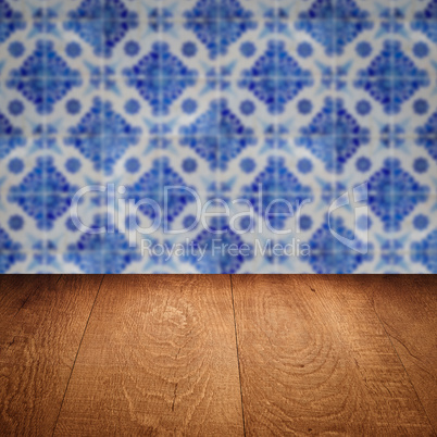 Wood table top and blur vintage ceramic tile pattern wall