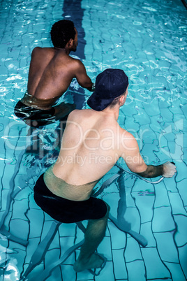 Fit men cycling in the pool