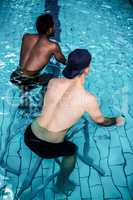 Fit men cycling in the pool