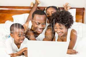 Happy family lying on the bed