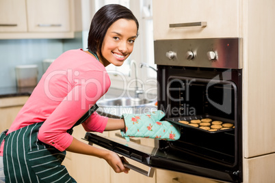 Smiling woman baking biscuits