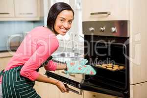 Smiling woman baking biscuits