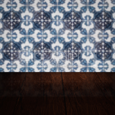 Wood table top and blur vintage ceramic tile pattern wall