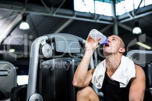 Muscular man drinking water