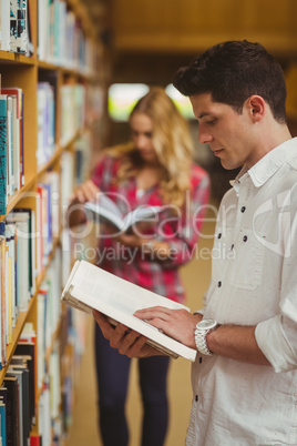 Concentrated male student reading book