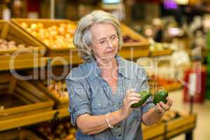 Senior woman holding two avocado