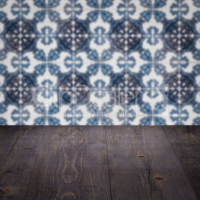 Wood table top and blur vintage ceramic tile pattern wall