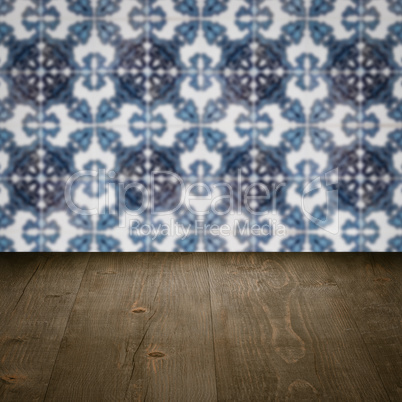 Wood table top and blur vintage ceramic tile pattern wall