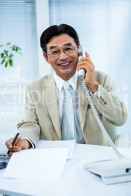 Smiling businessman talking on the telephone