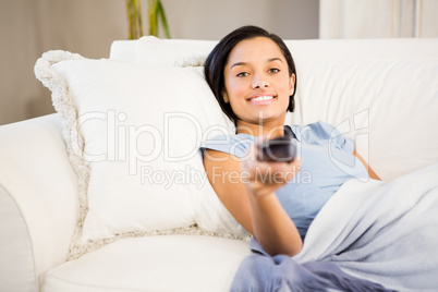 Smiling brunette using remote