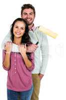 Portrait of happy couple holding paint roller