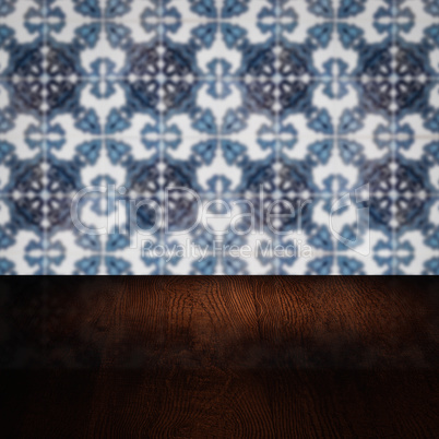 Wood table top and blur vintage ceramic tile pattern wall