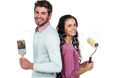 Smiling couple holding paint brushes