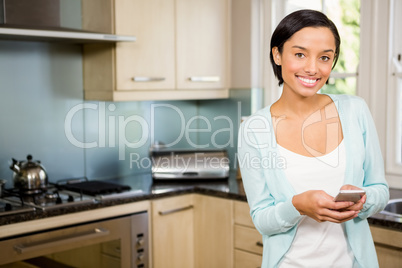 Smiling brunette using smartphone