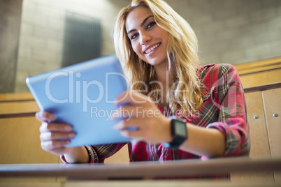 Smiling female student using tablet