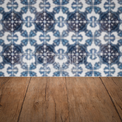 Wood table top and blur vintage ceramic tile pattern wall