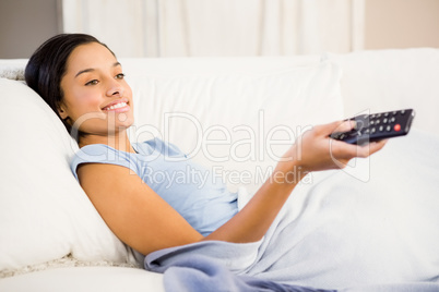 Smiling brunette using remote