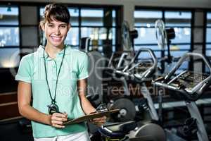 Smiling trainer holding clipboard