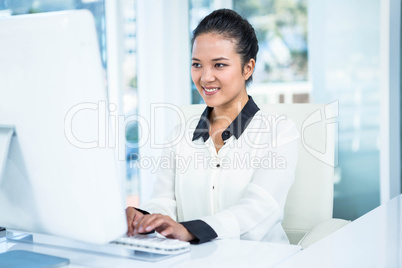 Smiling businesswoman typing on her computer