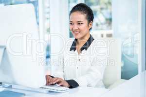 Smiling businesswoman typing on her computer