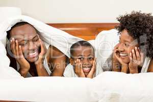 Happy family smiling under blanket