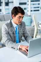 Concentrated businessman typing on computer