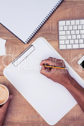 Cropped image of businessman writing on pad