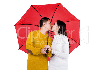 Couple kissing under umbrella