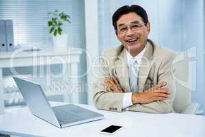 Smiling businessman with crossed arms
