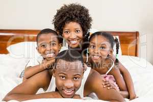 Happy family lying in bed together