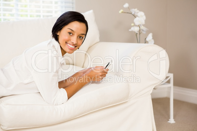 Smiling brunette using smartphone