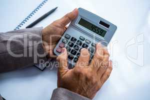 Businessman holding and using calculator