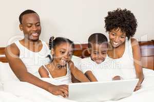 Happy family lying in bed together