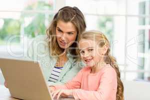 Mother and daughter using laptop