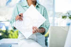 Smiling businesswoman sitting on her desk