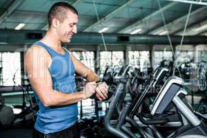 Smiling muscular man using stopwatch