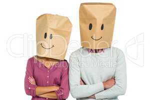 Couple covering their faces with paper bag with arms crossed