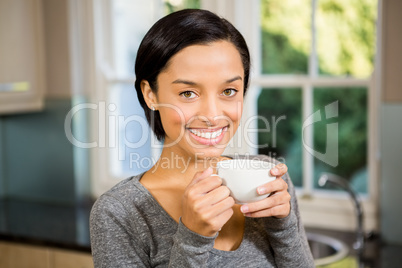 Smiling brunette holding white mug