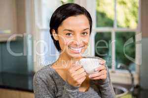 Smiling brunette holding white mug