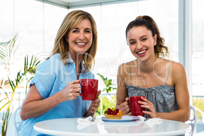 Mother and daughter eat breakfast