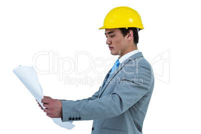 Concentrated asian businessman looking at a blueprint