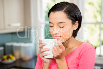 Peaceful brunette holding white cup